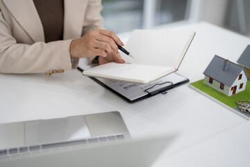 Professional Real Estate Agent Hand Holds Pen Points Notebook Discussing Property Sales Contract Business Home Buying Investment Strategy