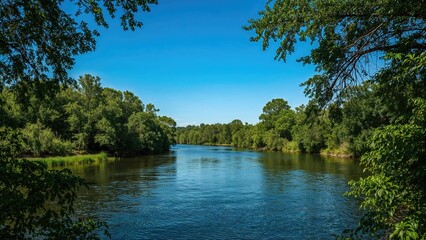 A peaceful river scenery framed by lush green foliage, with a gentle river flowing through, forming a tranquil natural border between the vibrant riverbanks.