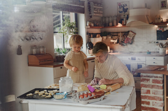 Family holiday baking with grandma in cozy kitchen.