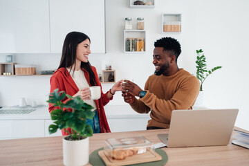 Diverse couple sharing morning coffee in kitchen