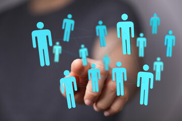 Digital concept of a network of people connected by a network of lines and a hand interacting with digital interface