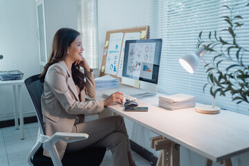 Asian businesswoman working late in a modern office, analyzing business data and charts on a computer screen, demonstrating dedication and professional commitment to her corporate responsibilities