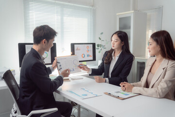Business professionals discussing financial data and charts during a corporate meeting in a modern office, collaborating on market analysis and strategic planning