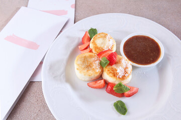 Cheesecakes with strawberries and jam. Healthy and nutritious breakfast. View from above. An illustration for the menu.
