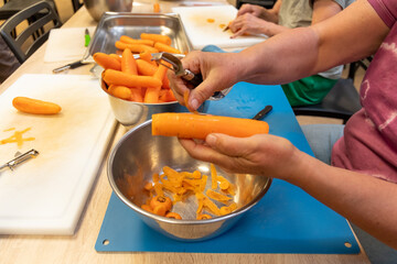 Frau schält eine Schüssel voller Karotten