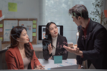 Asian business colleagues discussing strategy and planning new ideas during a collaborative meeting in a modern office, fostering teamwork and professional cooperation