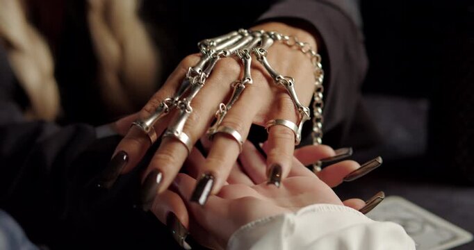 Witch reading client palm in mystical ritual