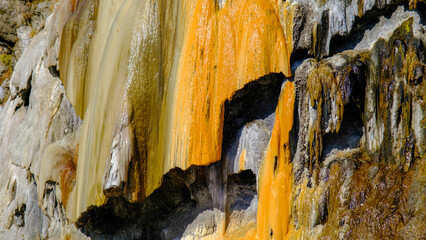 travertine waterfall close-up image, with mineral waters, the waterfall turned into chalky and colorful travertines.