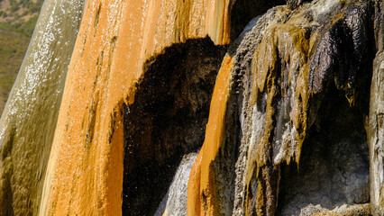travertine waterfall close-up image, with mineral waters, the waterfall turned into chalky and colorful travertines.