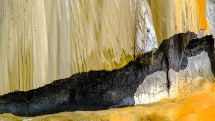 travertine waterfall close-up image, with mineral waters, the waterfall turned into chalky and colorful travertines.