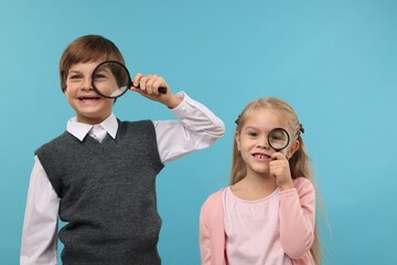 Children with magnifying glasses on light blue background