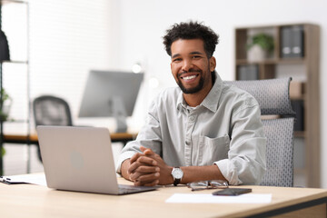 Portrait of man at table in office
