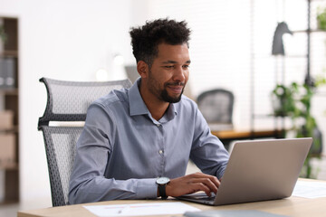 Man working on laptop at table in office