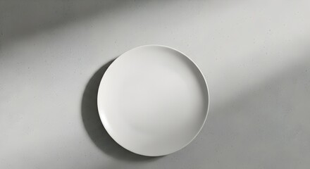 Empty White Round Plate on Grey Concrete with Sunlight Shadows