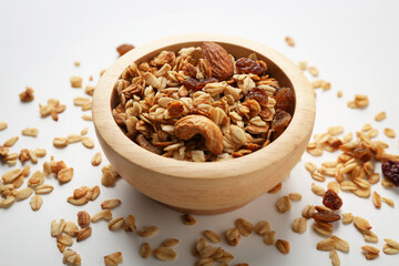 Tasty granola with nuts and raisins on white table, closeup