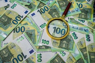 Euro banknotes with magnifier, money inspection, audit, fraud detection and financial control...