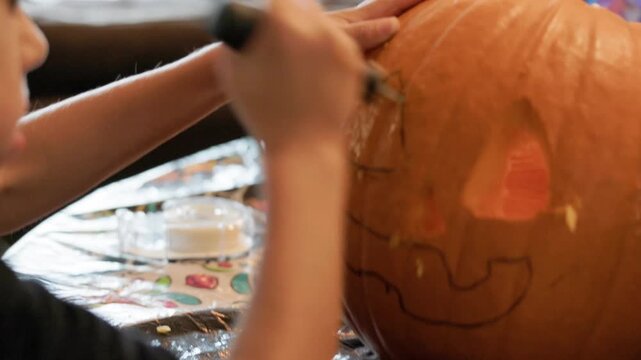 Young boy carving a pumpkin for halloween