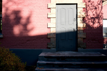 Shadows dance on a door's frame in soft morning light