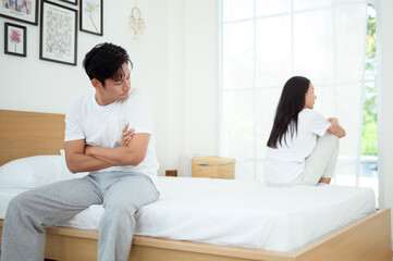 Couple Sitting Apart in Bedroom Experiencing Emotional Distance and Conflict During a Quiet Moment