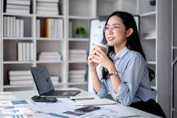 Accounting business concept, Accountant woman drinking coffee and looking outside to take a break with