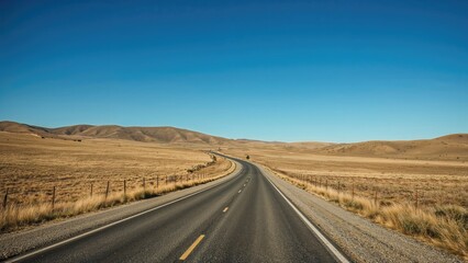 Country road across the steppe with open landscape and blue sky.