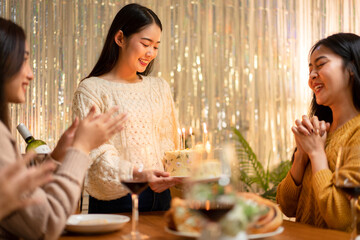 Young Asian Women Celebrating Birthday Party with Cake and Candles Friendship Gathering at Home Festive Mood Warm Lighting Happy Moments