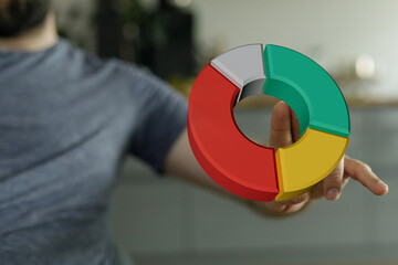 A man's hand holds a vibrant pie chart illustrating data analysis. The image is perfect for illustrating business concepts, statistical analysis