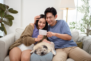 Expectant Couple Happily Shares Ultrasound Image in Cozy Living Room Setting