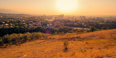 Scenic, wide-angle evening view of Almaty, Kazakhstan, as seen from Kok-Tobe Mountain at sunset