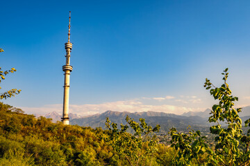 Fototapeta premium Scenic view of the Almaty Television Tower, the world's tallest free-standing tubular steel structure, on the slopes of Kok-Tobe in Almaty, Kazakhstan, with Altai Mountains in the background