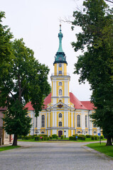 Stunning yellow church with red roof and green spire, Pokoj, Poland