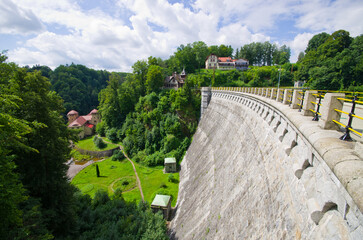 Majestic concrete dam structure surrounded by lush green forest