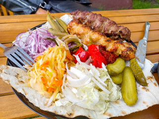 Delicious grilled kebab plate with fresh vegetables