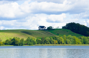 Peaceful home on green hill overlooking calm blue lake, Kaszuby, Poland
