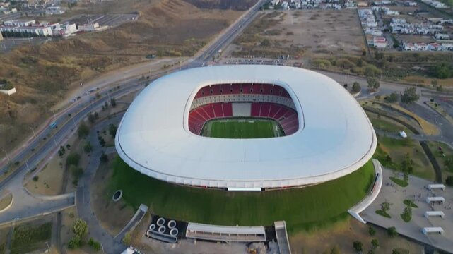 Aerial front pan revealing Akron Stadium's main entrance, architecture and dry surrounding area