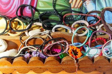 A variety of hair ties and accessories are scattered in a wooden box, showcasing vibrant colors and...