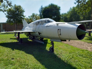 Vintage Mig-21 fighter jet sitting on green grass display