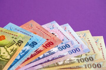 Thai baht money bills in big amount on purple close up. Finance and banking concept