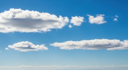 Fluffy white cumulus clouds drift across a clear, bright blue sky on a sunny day