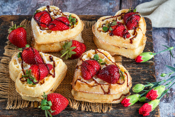 Heart-shaped belgian waffles decorated with fresh strawberries