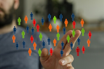 A hand touches a screen with colorful human icons. Illustrating connection, diversity, and teamwork...
