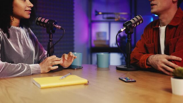 African American female radio host talking with male guest during live podcast - Powered by Adobe