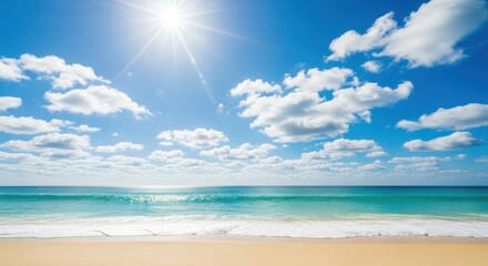 Bright sunny day at the beach with clear blue sky, white clouds, and turquoise ocean waves gently lapping the shore