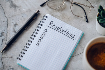 New Year 2026 resolutions list with laptop and coffee cup on desk, goals planning