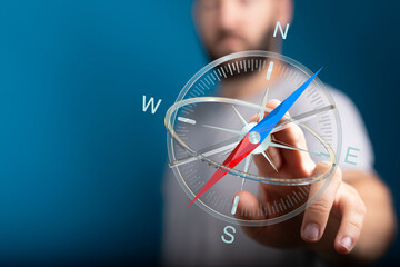 Close up of a man holding a compass, representing direction, navigation, guidance, and decision-making in business and personal life.