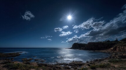 Under the bright moon calm waves lap against rocky shores creating a peaceful nighttime atmosphere.