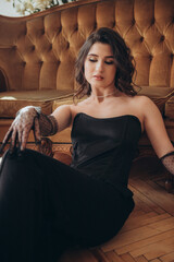 Chic woman in black outfit sitting gracefully indoors