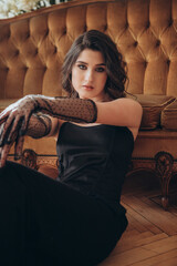 Elegant woman with gloves posing in black dress