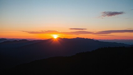 Fototapeta premium Gorgeous sunset above mountains at dusk with vibrant sky and silhouetted peaks.