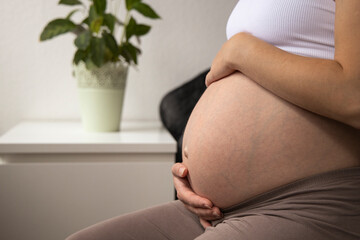 pregnant young woman sits in the bed